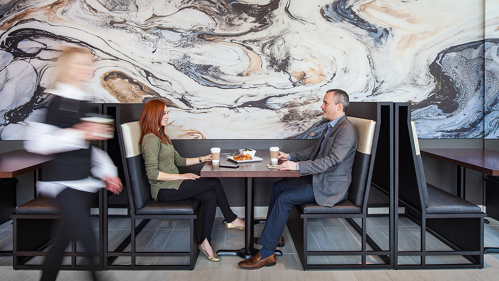 A man and woman sitting at a table with drinks.